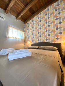una camera da letto con un letto e due asciugamani di Al Teatro a Reggio di Calabria