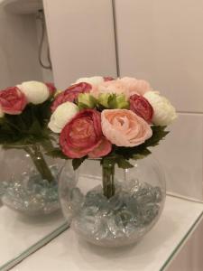 un vase rempli de fleurs roses et blanches sur une table dans l'établissement Apartment Slavica, à Lozovac