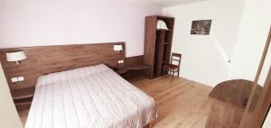 a hotel room with a bed and a chair at Hôtel des Pyrénées - Entre Bastille et Nation in Paris