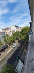 a view of a city street with a car on the road at Hôtel des Pyrénées - Entre Bastille et Nation in Paris