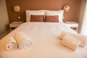 ラーヴラにあるAr d'Sal - Praia de Angeiras - Beach&GoodFoodのタオルが敷かれたベッドのある寝室