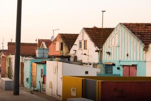 una hilera de casas con puertas y tejados coloridos en Ar d'Sal - Praia de Angeiras - Beach&GoodFood, en Lavra