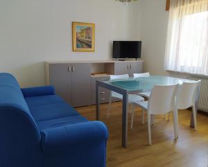 sala de estar con mesa y sofá azul en Siora Lina Appartamenti, en Vigo di Cadore