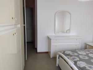 1 dormitorio con 1 cama y vestidor con espejo en Siora Lina Appartamenti, en Vigo di Cadore