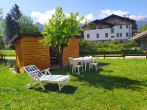 una mesa y sillas en un patio con un árbol en Siora Lina Appartamenti, en Vigo di Cadore