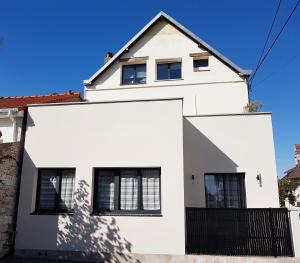 a white house with a black fence at LES VAGUES, plage et centre à pied, terrasse rez-de-ch, parking gratuit, lits faits, animal bienvenu in Berck-sur-Mer