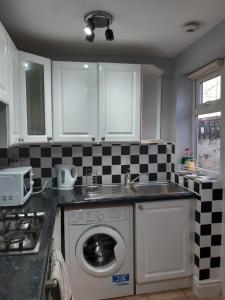 a kitchen with a washing machine and a sink at Hanwell House in Liverpool