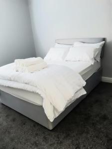 ein großes weißes Bett mit weißer Bettwäsche und Kissen in der Unterkunft Hanwell House in Liverpool