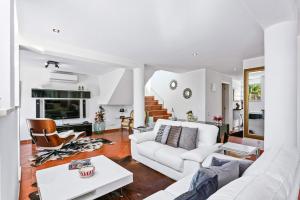 ein Wohnzimmer mit einer weißen Couch und einem Tisch in der Unterkunft Villa Maresia Dourada in Guia