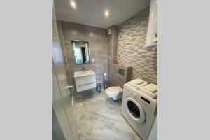 uma casa de banho com uma máquina de lavar roupa e um lavatório em LUX 1BD/1BA City Center Apartment em Blagoevgrad