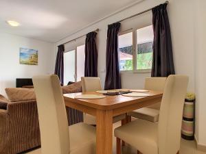comedor con mesa de madera y sillas en Hacienda Golf Resort - 8408, en Sucina