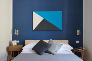 那不勒斯Daglinn House的一间卧室设有蓝色的墙壁和一张带枕头的床。