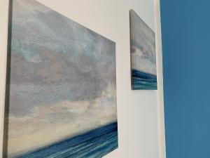 two paintings of the ocean on a wall at Indipendent Blue in Ferrara