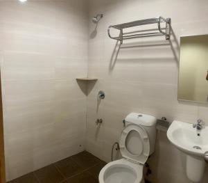 La salle de bains est pourvue de toilettes et d'un lavabo. dans l'établissement Grand Hotel 2, à Keningau