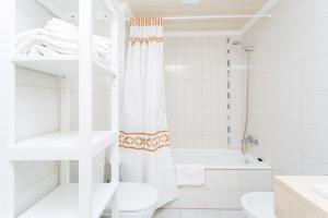 a white bathroom with a shower and a toilet at Oasis Fañabe Townhouse in Adeje +10 photos