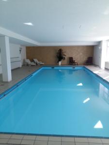 a large swimming pool in a building with blue lighting at Kuckuckstraum in Schönwald
