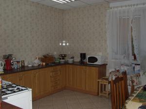 a kitchen with wooden cabinets and a counter top at MHostel in Piaseczno