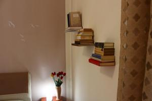 Pokój z kupą książek i wazonem z kwiatami w obiekcie BED&BOOK Palazzo Cutelli w mieście Palermo
