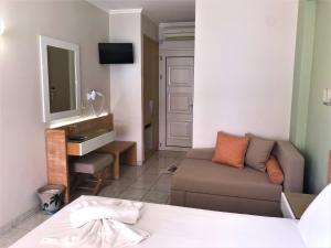 een woonkamer met een bank en een televisie bij Palm Trees Hotel in Nydri