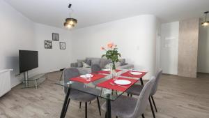 a dining room with a table and a couch at Lesna Dreams Apartament in Pobierowo