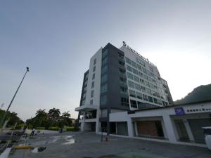 un edificio alto frente a un estacionamiento en UrbanStay Industrial en Ipoh