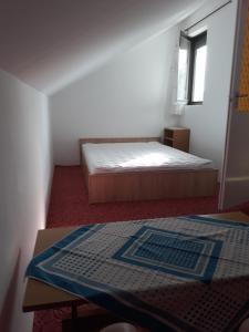 Un dormitorio con una cama y una mesa. en Retrovilla, en Balatonkenese