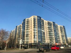 a large building with cars parked in front of it at River Park apartments in Dnipro
