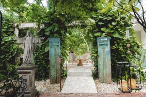 a statue of a christ the redeemer in a garden at LA TULUMEÑA Boutique Hotel in Tulum