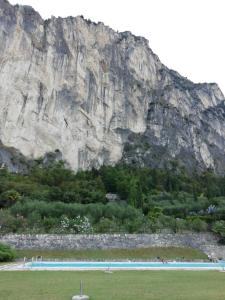 una gran montaña en la distancia con una piscina en LAKE & CASTLE VIEW apartment, en Riva del Garda