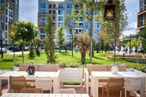 an outdoor patio with tables and chairs and a park at Luxury Studio Mamaia Nord in Mamaia Sat/Năvodari