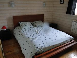 ein Bett mit weißer Bettwäsche und Kissen in einem Schlafzimmer in der Unterkunft Ty Clara in Landéda