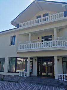 een wit gebouw met een balkon erboven bij Agropensiunea Ozon in Piatra Neamţ