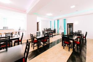 a dining room with black tables and chairs at Agropensiunea Ozon in Piatra Neamţ