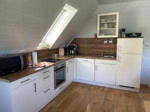 uma cozinha com armários brancos e um lavatório em MeinJork em Jork