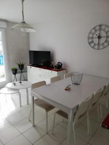 a white dining room with a white table and chairs at Vie de famille in Sainte-Cécile-Plage +16 photos