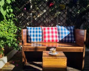 un banco con almohadas y una taza de café sobre una mesa en Cabo da Vila Guesthouse, en Ribeira Grande