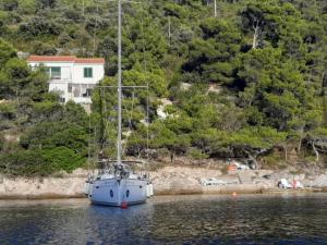a sailboat in the water in front of a house at Apartment Nono Ivo in Vis