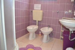 a pink bathroom with a toilet and a sink at Apartments Lucija in Srima +31 photos