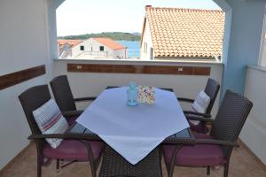 a table and chairs on a balcony with a view of the water at Apartments Lucija in Srima