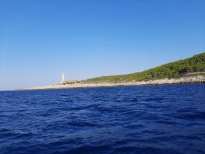 a large body of water with a lighthouse in the background at Apartment Nono Ivo in Vis