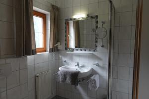 een witte badkamer met een wastafel en een spiegel bij Apart La Stella in Kappl