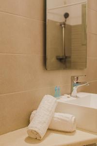 W łazience znajduje się biały ręcznik na zlewie. w obiekcie Maistrali w mieście Livadion