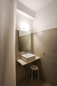 baño con lavabo, espejo y taburete en Maistrali, en Livadion