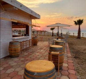 a row of wooden barrels in front of a bar at Residence Rosa in Margherita di Savoia