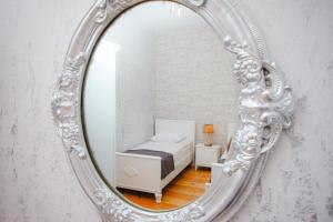 a mirror reflecting a bedroom with a bed in it at Mkhitaryan Guest House in Gyumri