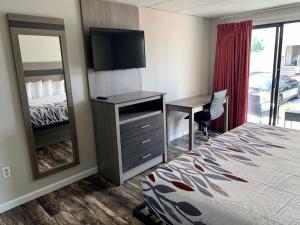 ein Hotelzimmer mit einem Bett, einem Schreibtisch und einem Spiegel in der Unterkunft Simple Life Motel in Ocean City
