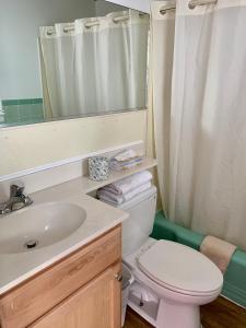大洋城的住宿－Simple Life Motel，一间带卫生间、水槽和镜子的浴室