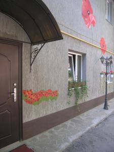 uma parede com flores pintadas ao lado de um edifício em Art Villa on Sumskaya Street em Kharkov