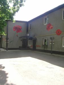 a building with red flowers painted on the side of it at Art Villa on Sumskaya Street in Kharkiv