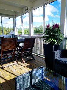 a screened in porch with two chairs and a table at Hannaksen tila in Korppoo